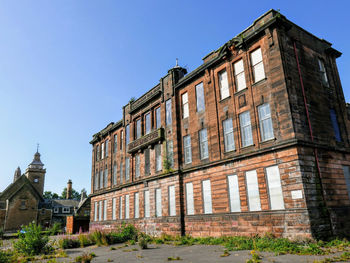 Low angle view of old building against clear blue sky