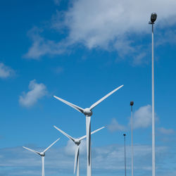 Low angle view of windmill against blue sky