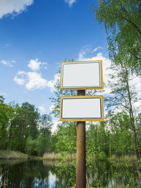 Low angle view of information sign against blue sky