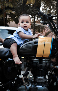 Full length of baby boy sitting on motorcycle