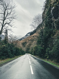 Road amidst trees against sky