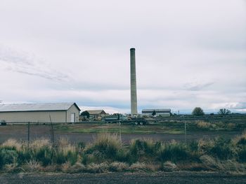 Factory on field against sky