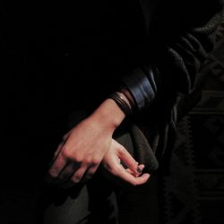 Close-up of woman hand against black background