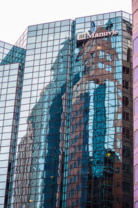 Low angle view of glass building against sky