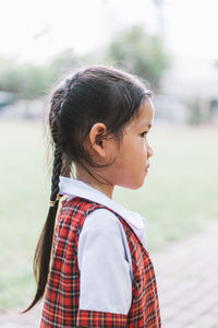 Side view of schoolgirl standing at field