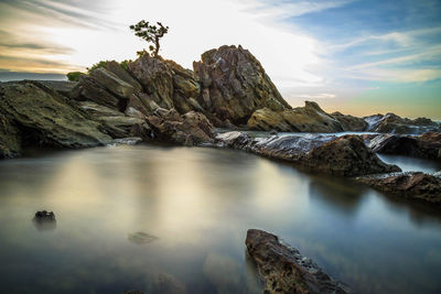 Scenic view of rocks in sea against sky