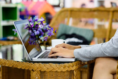 Midsection of man using mobile phone while sitting on table