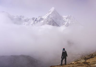 Rear view of man on snowcapped mountain