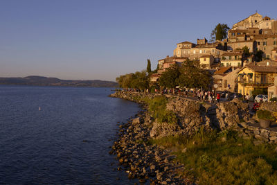 Scenic view of sea and buildings against clear blue sky