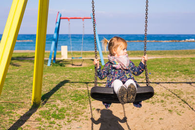 Girl sitting on swing at playground