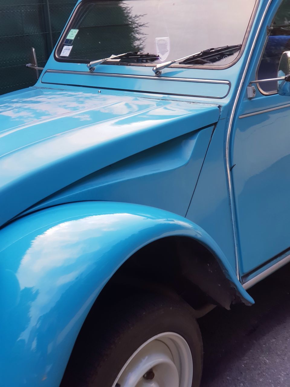 REFLECTION OF BLUE CAR ON MIRROR