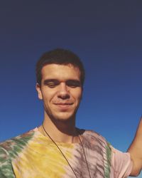  young man standing against blue sky