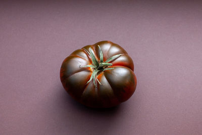 Large dark tomato on brown background