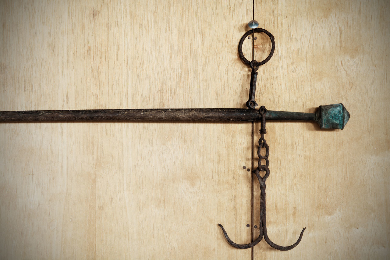 CLOSE-UP OF CROSS HANGING ON WOOD