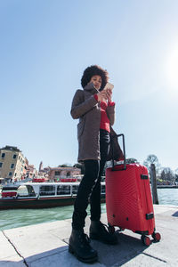 Woman standing on motorcycle against sky