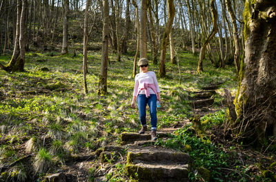 Rear view of woman walking in forest