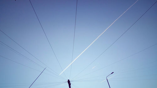 Low angle view of power lines against clear blue sky