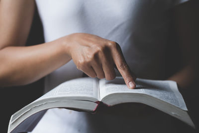 Midsection of man holding book