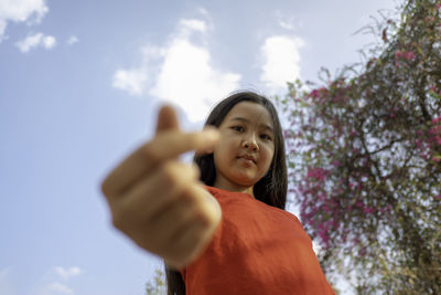 Portrait of girl standing against sky