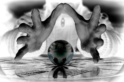 Digital composite image of hand drinking glass on table
