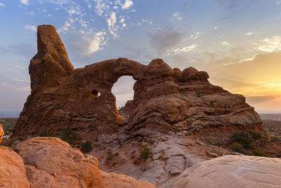 Silhouette of a hiker framed in turret arch at sunset in arches park