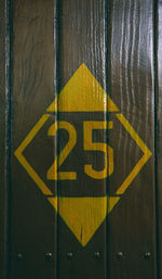 Close-up of yellow sign on wall