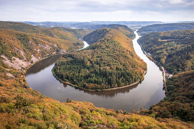 High angle view of river amidst trees against sky