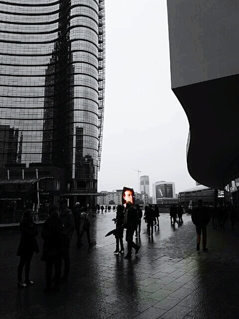 PEOPLE WALKING ON ROAD AGAINST BUILDINGS