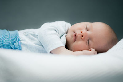 Cute baby boy sleeping on bed at home