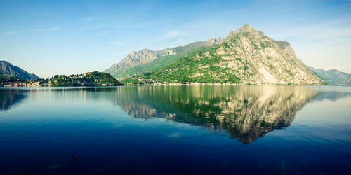 Scenic view of lake and mountains against blue sky