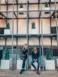 Full length of people sitting outside building