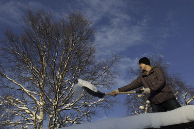 Man cleaning snow on house