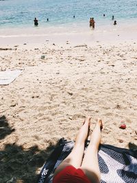 Low section of woman relaxing on beach