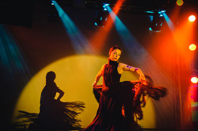 Full length of woman standing in illuminated nightclub