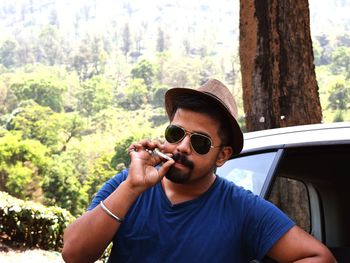 Portrait of man smoking cigarette in forest