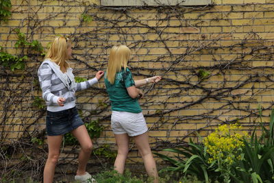 Girls playing with plants against old abandoned building