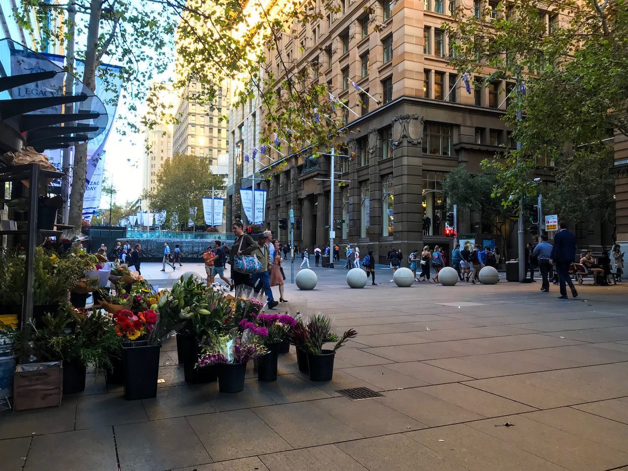 PEOPLE WALKING ON STREET AMIDST BUILDINGS