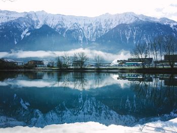 Reflection of snow covered mountains on calm lake