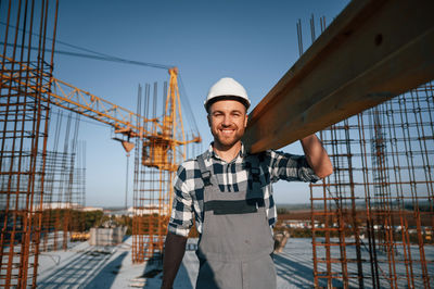 Portrait of young man standing against buildings