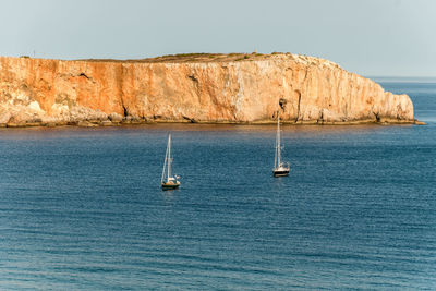 Sailboat sailing on sea against sky