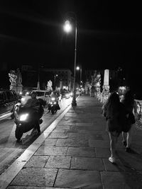 People on illuminated street at night