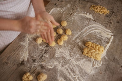 Cropped image of hand making breads on table