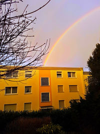 Rainbow over building against sky