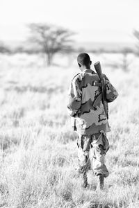 Rear view of man walking on field