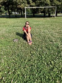 Portrait of woman sitting on grassy field