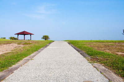 Pavilions with road forward against sky.