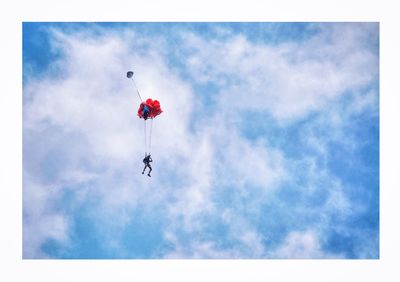 Low angle view of person paragliding against sky