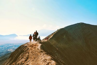 People on mountain against sky