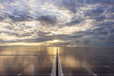 Solar panels in close-up with sunlight and a cloudy sky background