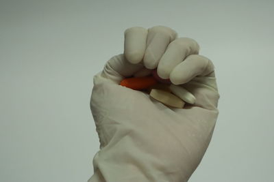 Close-up of man holding hands over white background